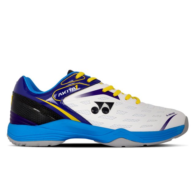 A Yonex Akita badminton shoe with a white mesh upper featuring midnight obsidian and blue accents, and a blue non-marking sole.