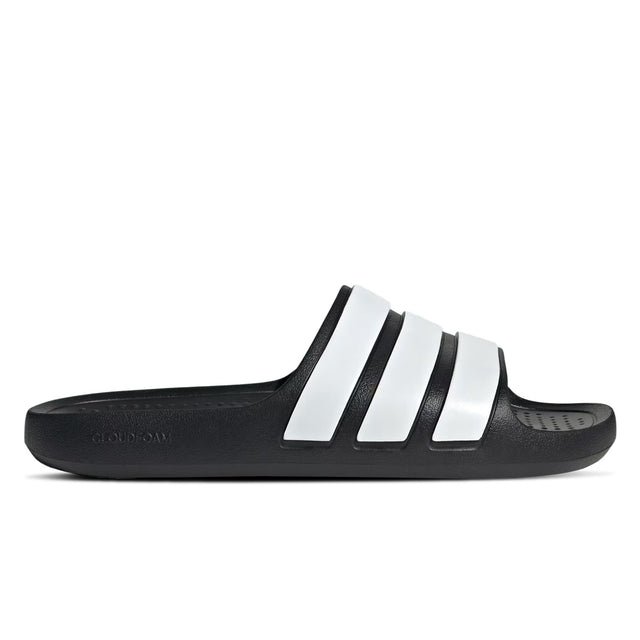 A pair of black and white adidas Adilette Flow slides.