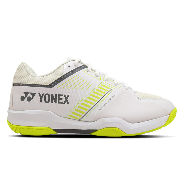 Yonex Strider Flow Wide badminton shoes in white and lime colors, featuring a synthetic upper material, rubber outsole, and Yonex branding on the side.