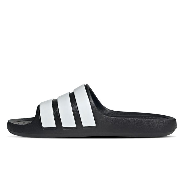 A pair of black and white adidas Adilette Flow slides - side view
