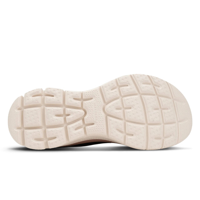 Close-up of a beige sneaker sole with tread pattern on a white background