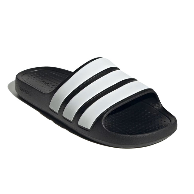 A pair of black and white adidas Adilette Flow slides.