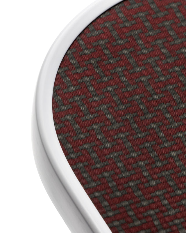 Close-up of a textured red and gray material with a metallic border on a white background