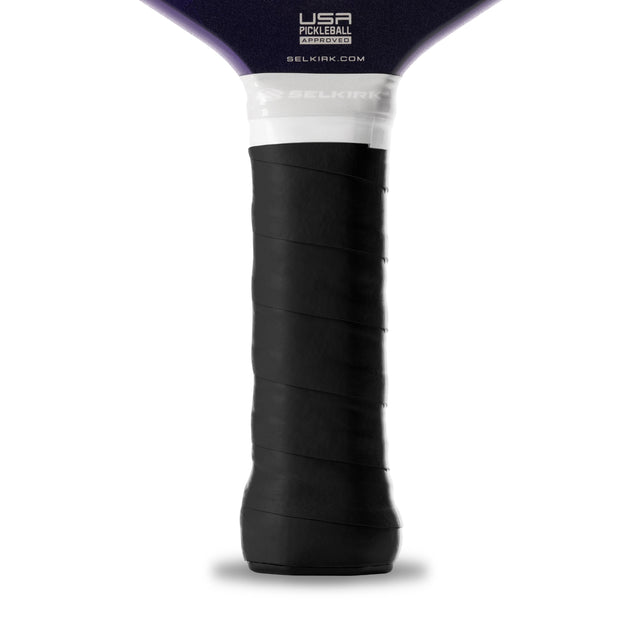 Close-up of a pickleball paddle handle with black grip and white label on a white background