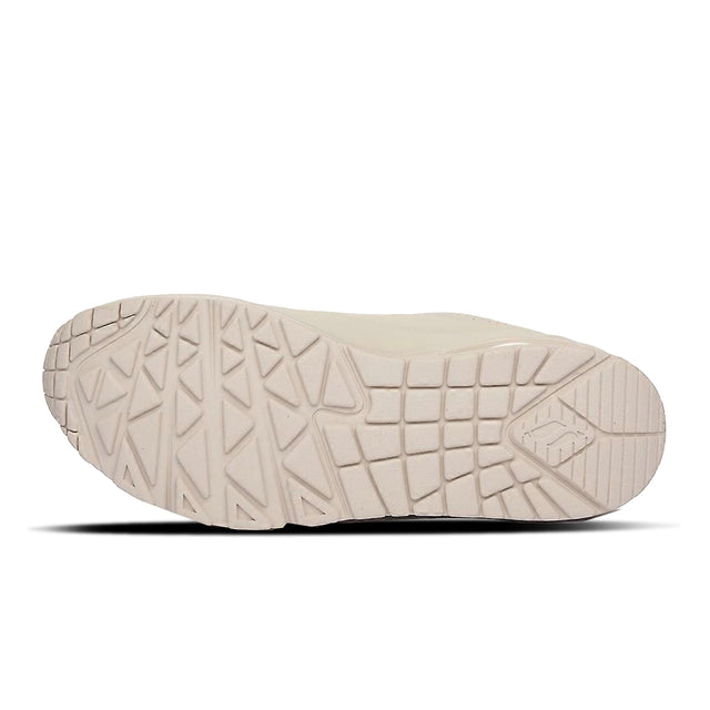 Close-up of a beige shoe sole with tread pattern on a white background