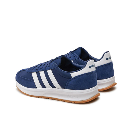 Blue Adidas sneakers with white stripes on a white background