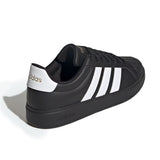 Black Adidas sneaker with white stripes on a white background