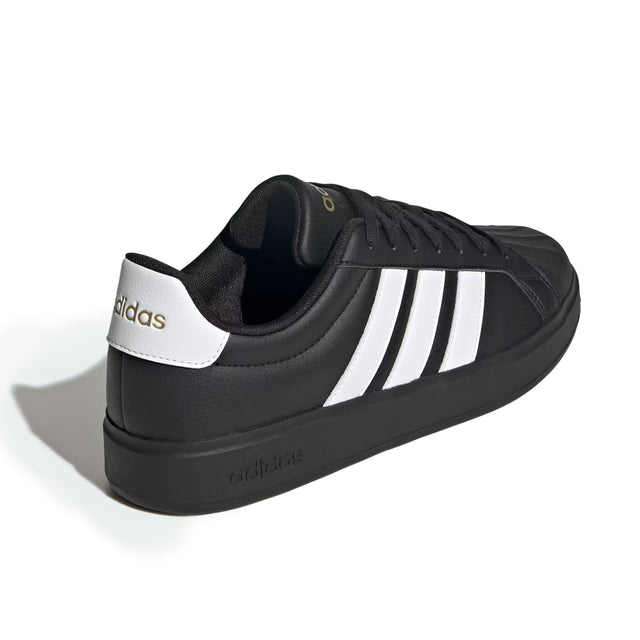 Black Adidas sneaker with white stripes on a white background