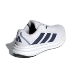 White athletic shoe with blue stripes on a white background