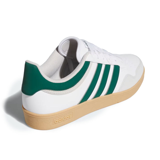 White Adidas sneaker with green stripes on a white background