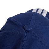 Close-up of a blue cap with a button on a white background