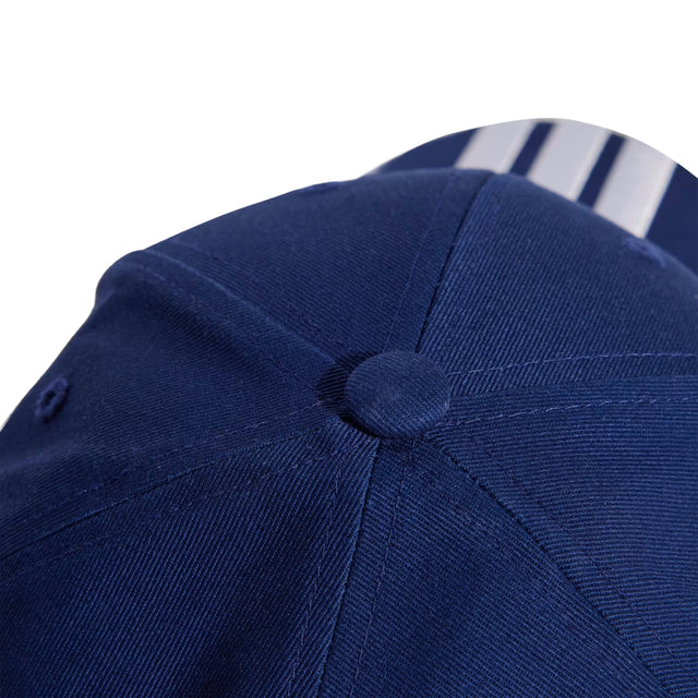 Close-up of a blue cap with a button on a white background