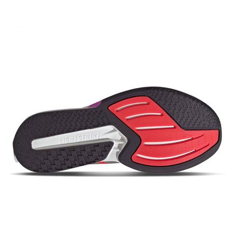 Close-up of a red and black shoe sole with 'Lightstrike' branding on a white background