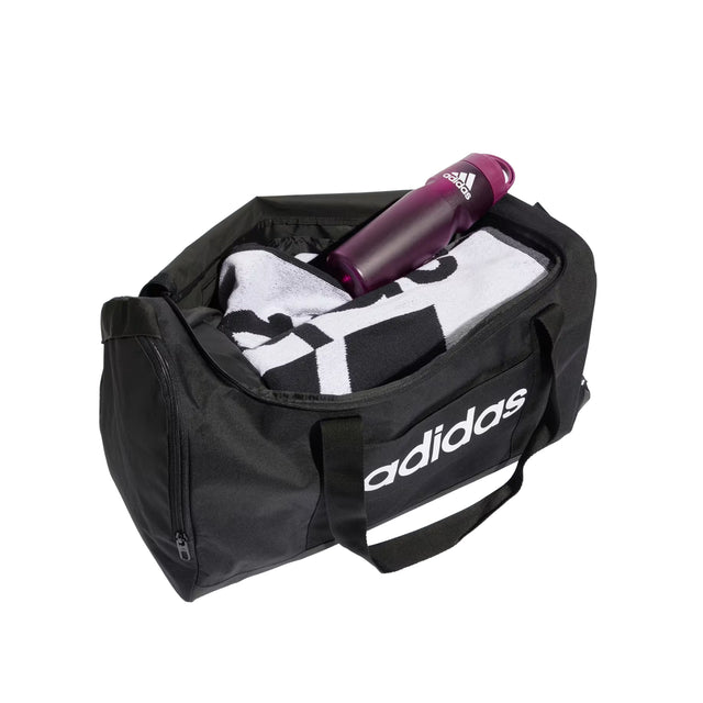 Black Adidas duffel bag with a towel and purple bottle on a white background