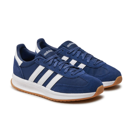 Blue Adidas sneakers with white stripes on a white background